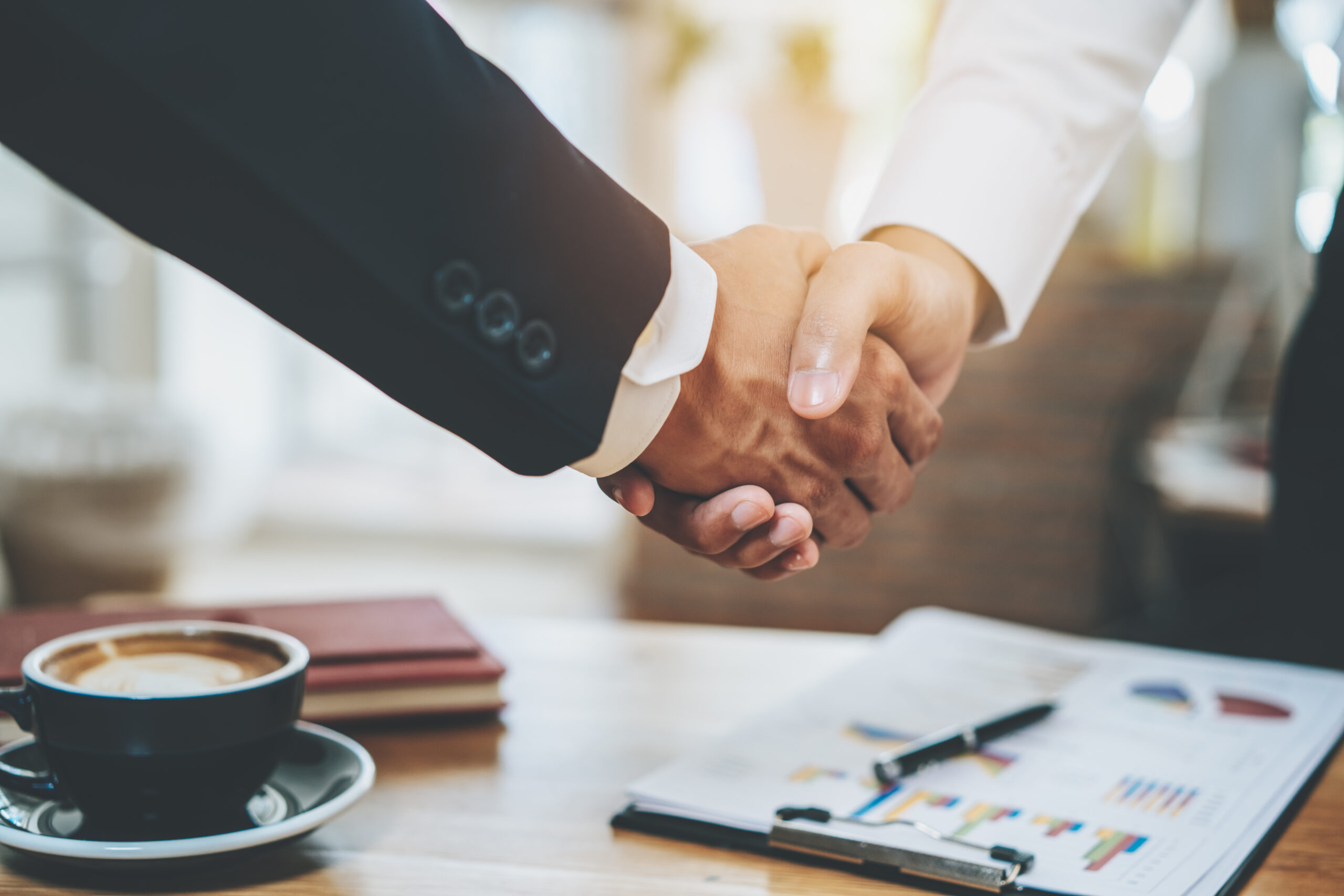 Erfolgreiche Partnerschaft im Versicherungsbereich Zwei Geschäftsmänner schütteln sich die Hand, symbolisch für erfolgreiche Kooperation im Bereich Versicherungen.